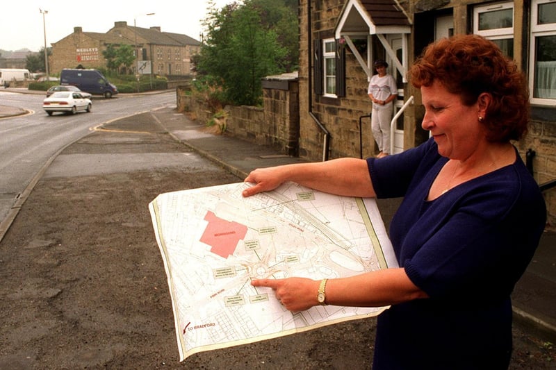 Elizabeth Dunsdale examines the plans for Guiseley's Park Road development. The roundabout will be in the background, with her home the nearest residence, shown with her daughter Amy standing in the doorway.