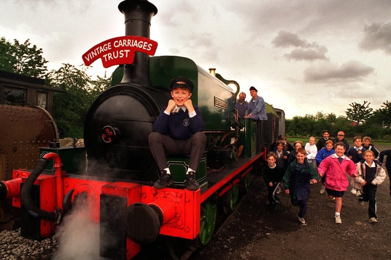 Pupil Robert Hall sits on the front of one of the steam engines at Middleton Railway, while some of his classmates from Middleton St Mary's CofE Primary dash to have a look.