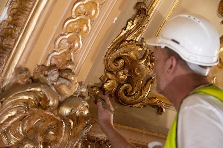 Skilled craftspeople working daily in tiny roof spaces to inspect and restore the ornate plasterwork from behind the ceiling.