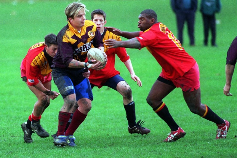 Morley amateur rugby league captain Damian Platt is tackled by three Harrogate defenders.