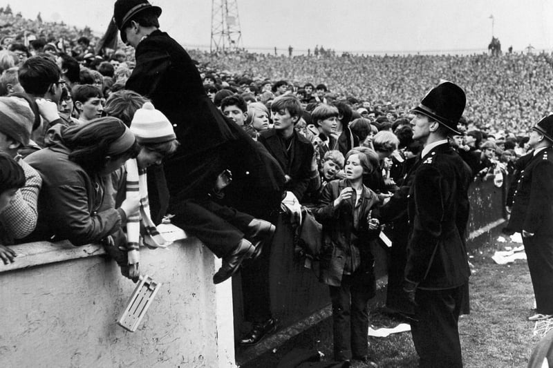 A policeman climbs into the crowd at Elland Road during Leeds United's clash with Everton in September 1966.