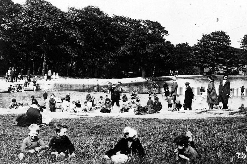 The cafe is visible in this undated photo. Children are playing in a paddling pool, a shallow area of the lake which has been fenced off for safety.