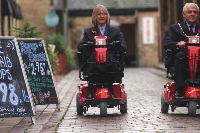 The Mayor and Mayoress of Wetherby, Couns Gerald and Rita Wilkinson, take a ride along The Shambles on new shopmobility scooters available for hire at the One Stop Centre.