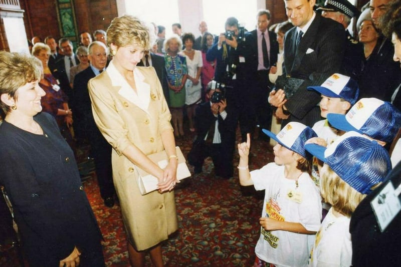Princess Diana looks on attentively at a deaf youngster using sign language at Blackpool Tower World