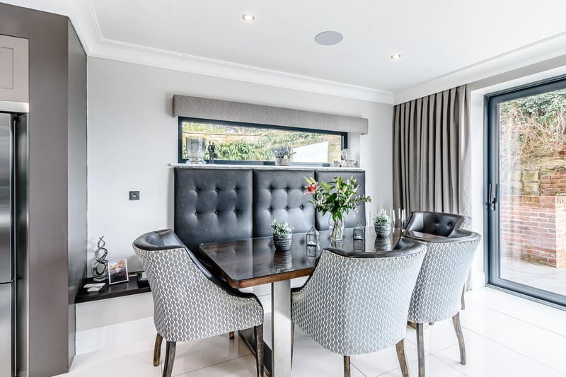The room is centred around a full height slate fireplace with remote control Faber gas fire, full height sliding glazed patio doors opening onto the rear sun terrace and remote-controlled voiles.