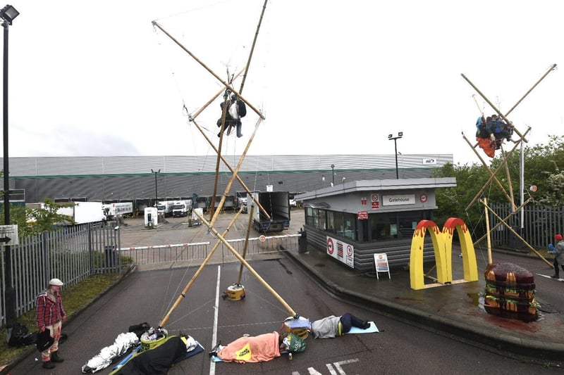 Animal Rebellion protesters suspended and attached to a bamboo structure outside a McDonalds distribution site in Hemel Hempstead, Hertfordshire, which is being blockaded to stop lorries from leaving the depot.