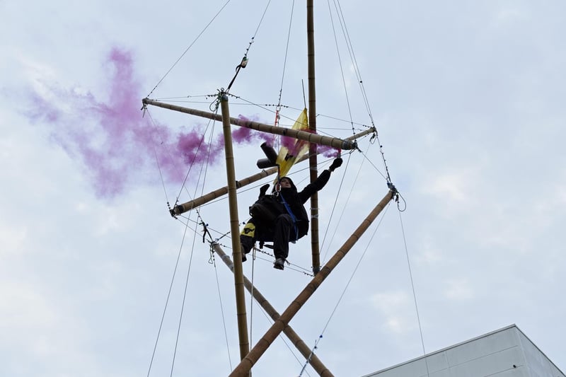 Animal Rebellion protester suspended from a bamboo structure outside a McDonalds distribution site in Basingstoke, Hampshire.