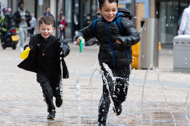 Theo (6) and Logan (9) run through the water fountains on Church Street.