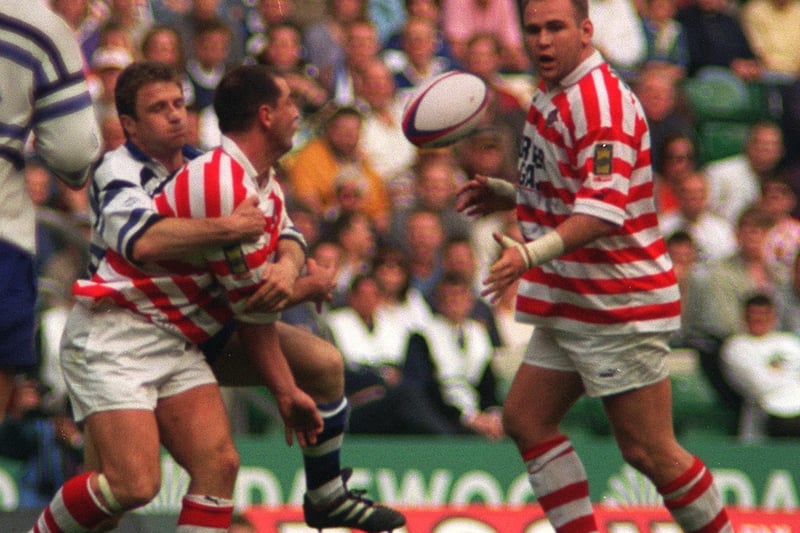 Wigan's Joe Lydon gets the ball away to Scott Quinnell.