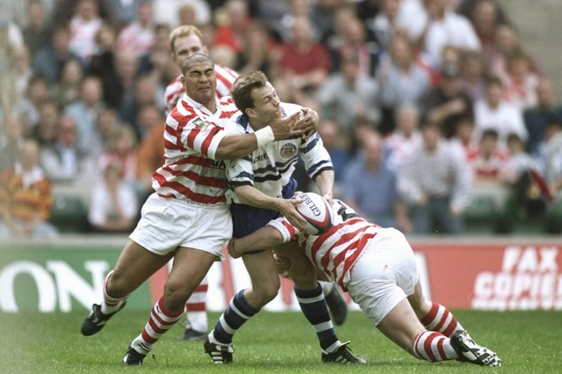 Ian Sanders (centre) of Bath is tackled by Va''aiga Tuigamala. Photo: Mike Hewitt/Allsport