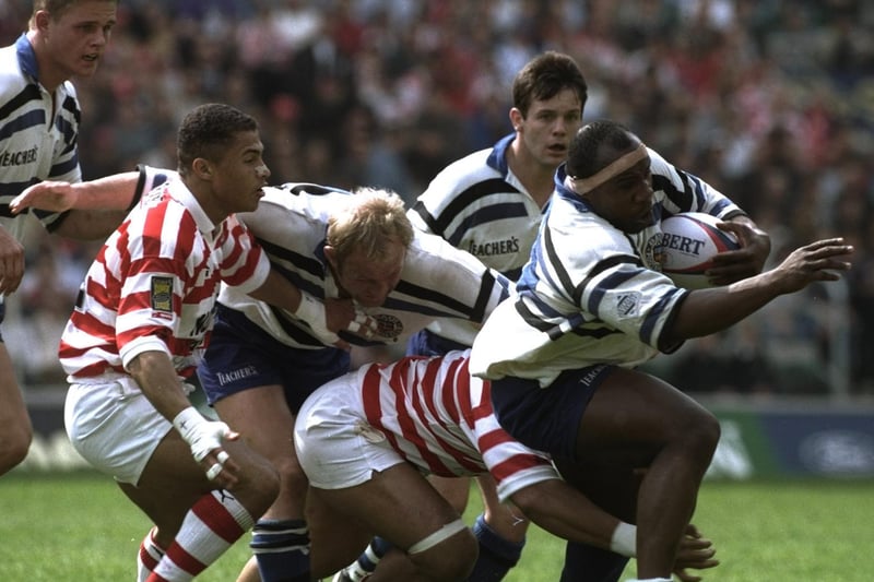 Victor Ubogu (right) of Bath charges away from the Wigan defence. Photo: Mike Hewitt/Allsport