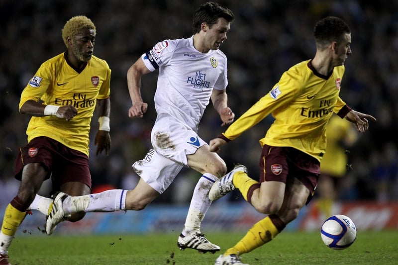 Jonny Howson drives forward despite the attention of Arsenal's Alexandre Song (left) and Laurent Koscielny during the FA Cup third round replay at Elland Road in January 2011.