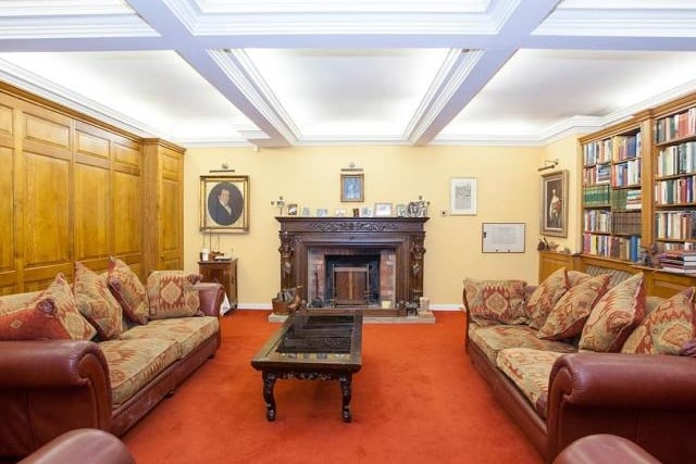 The spacious first reception room has stone mullion windows to the front, a feature window to the side and a fireplace with open fire.