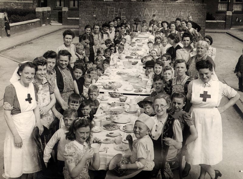 Dakins Road in Leigh 1945 celebrating VE Day - written in chalk on the wall 'war is over'.