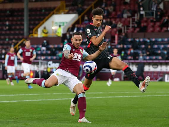 Josh Brownhill of Burnley shoots whilst under pressure from Rhys Williams of Liverpool during the Premier League match between Burnley and Liverpool at Turf Moor on May 19, 2021 in Burnley, England.