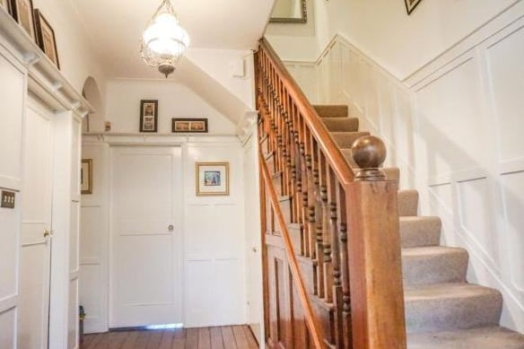 The grand solid wood stairway leads from the entrance hallway up to the second floor.