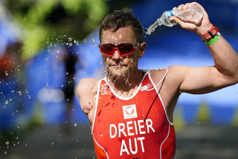 Oliver Dreier pours water over himself as he competes in the running stage of the AJ Bell 2021 World Triathlon Para Series race in Roundhay Park, Leeds. (photo: PA Wire/ Danny Lawson)
