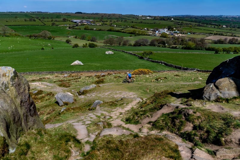 A mountain bike cyclist makes his way along the tracks and bumps around the back of Almscliffe Crag, a large outcrop of Millstone Grit which stands above the Lower Wharfe Valley to the south of Harrogate.