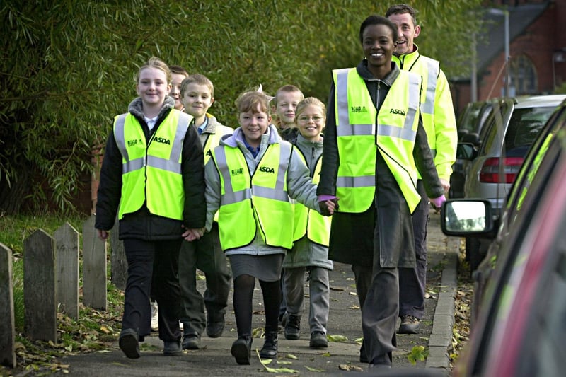 November 2002 and Sara Asani leads Hugh Gaitskell Primary School pupils Demi Middleton and Rebecca Evans as part of the new Asda walking bus scheme in Beeston.