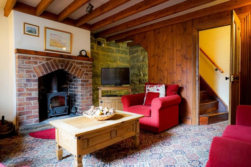 Beams and a brick fireplace add to the cosiness of this main room within the property.
