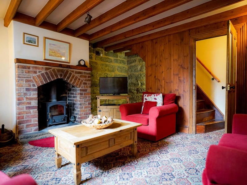 Beams and a brick fireplace add to the cosiness of this main room within the property.