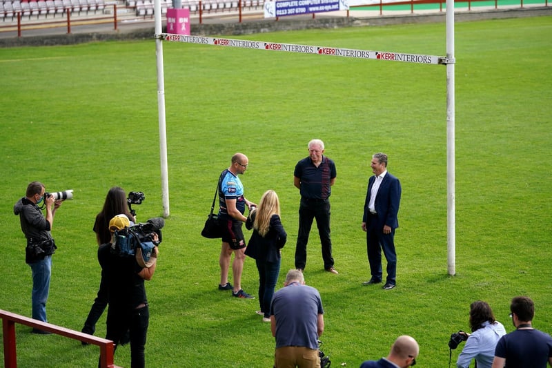 Sir Keir and Ms Leadbeater with club chairman Kevin Nicholas while the assembled media look on during their visit to Batley. Photo: Getty Images