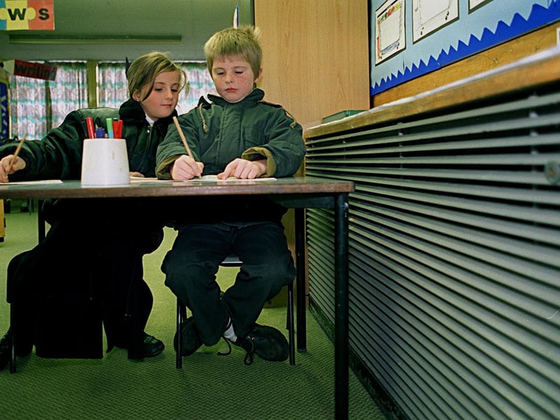 Pupils Carrie Blakeley and Paul Leabeatter wear their winter coats because of a faulty heating system at Fieldhead Junior and Infant School.
