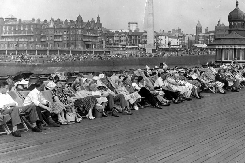 Holidaymakers relaxing in deckchairs on North Pier in 1955