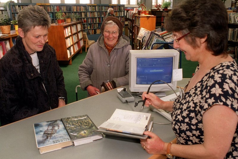 Library Assistant Vivian Tomlinson uses the new computer to issue books at Armley Library to Margaret Shaw and Clarice Whitaker in May 1996.