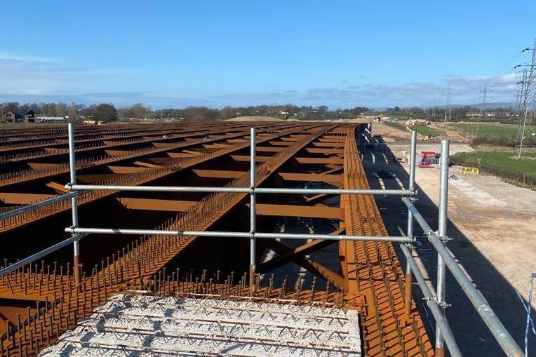 The cantilever formwork system (paraslims) used for construction of the deck edge has been installed, on a section of the viaduct above the railway