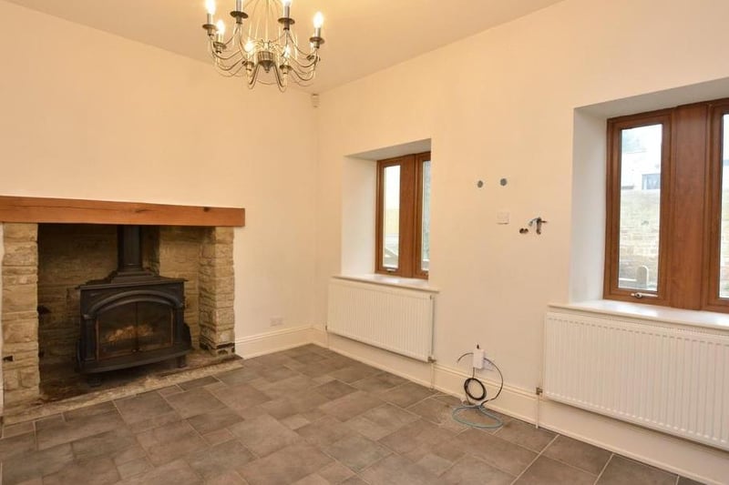 An original stone brick archway opens into a breakfast room, a spacious room which features a wood burning stove. There is also a formal dining room for entertaining.