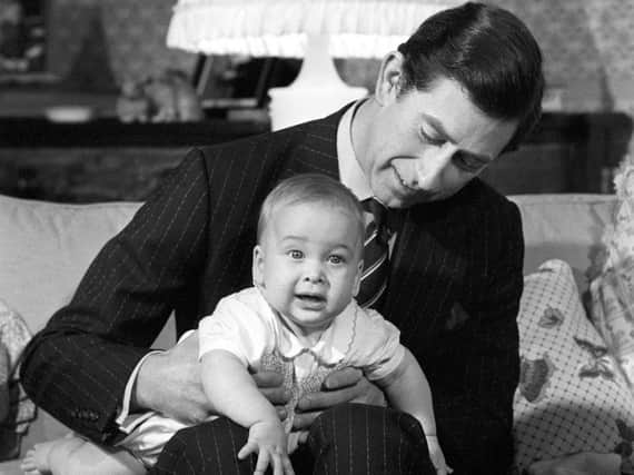 Prince Charles cradling his son Prince William at Kensington in 1982