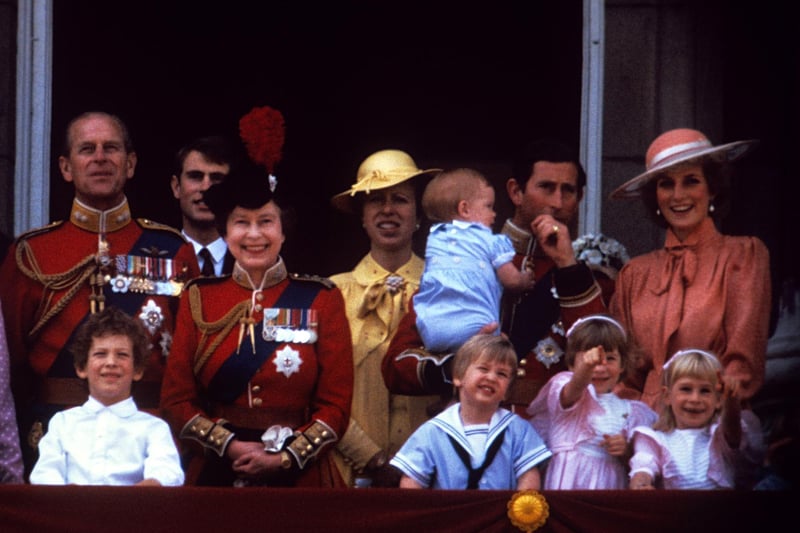 The Duke of Edinburgh, Prince Edward, Queen Elizabeth II, Princess Anne, the Prince of Wales holding Prince Harry, the Princess of Wales, and Prince William on the balcony of Buckingham Palace, London, in 1985