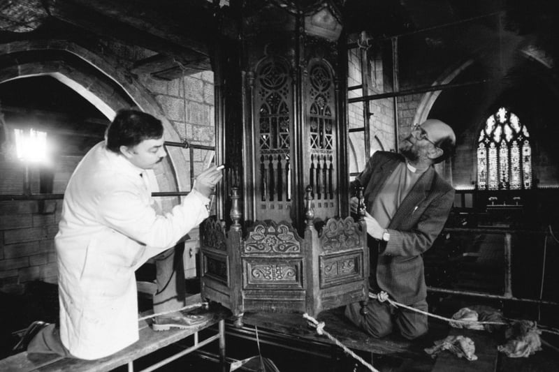 Francis Downing restores one of the finest treasures at St. Wilfrid's Church in Calverley in January 1991. He is watched by Canon David Sutcliffe. The restoration work was paid for thanks to a grant from the Pilgrim Trust.