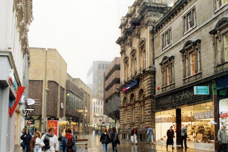 Commercial Street in Febuary 1991. Shops on the left include Radio Rentals TV hire and K shoe shop, with Boots chemists further along past the junction with Albion Street. On the right are Russell And Bromley footwear and Britannia Building Society.