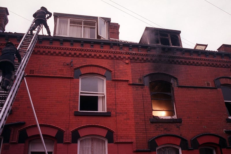 Firefighters clamber on to the roof of a house in Harehills from where a woman was rescued after a fire in January 1999.