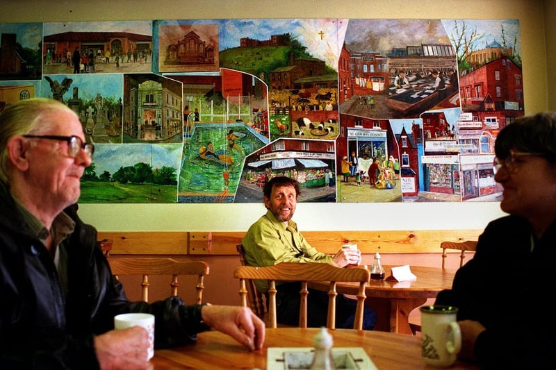 November 1999 and pictured is artist Brian Holmes (centre) with his mural at The Meeting Point Cafe and Social Centre in Harehills.