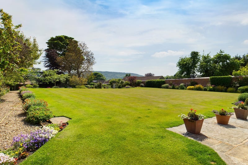 Lawn, pathways and established borders within the well kept gardens