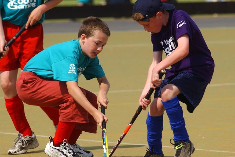 Kirklees hockey player Ashley Cooke (right) locks sticks with Calderdale player Georges Moss.