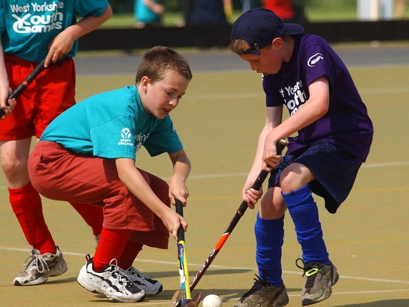 Kirklees hockey player Ashley Cooke (right) locks sticks with Calderdale player Georges Moss.