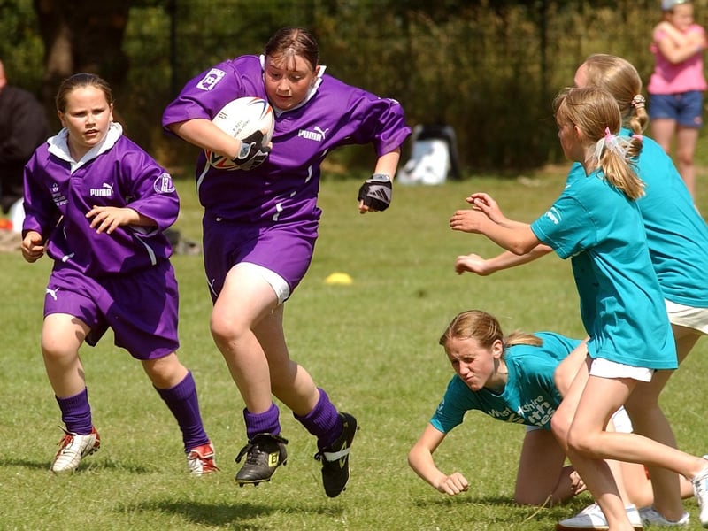 Bradford player Vicky Exley charges past the tackles of the Calderdale players to score a try.