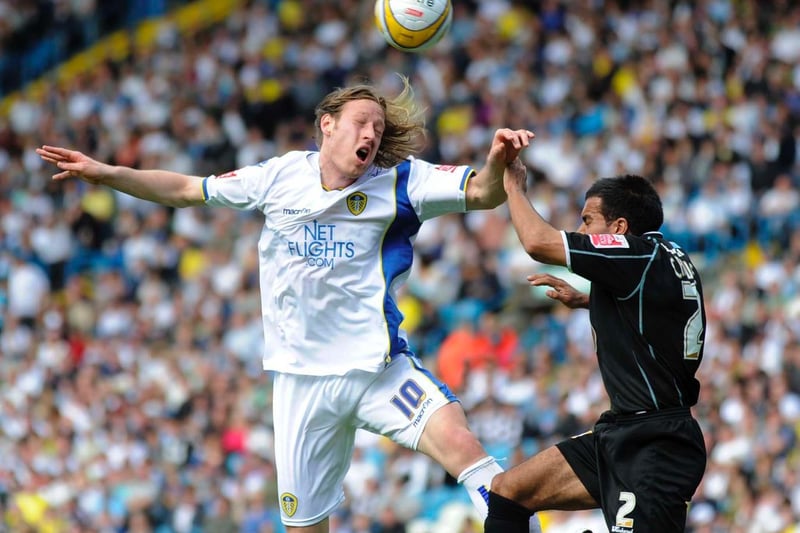 Striker Luciano Becchio rises high with Northampton Town's Jason Crowe.