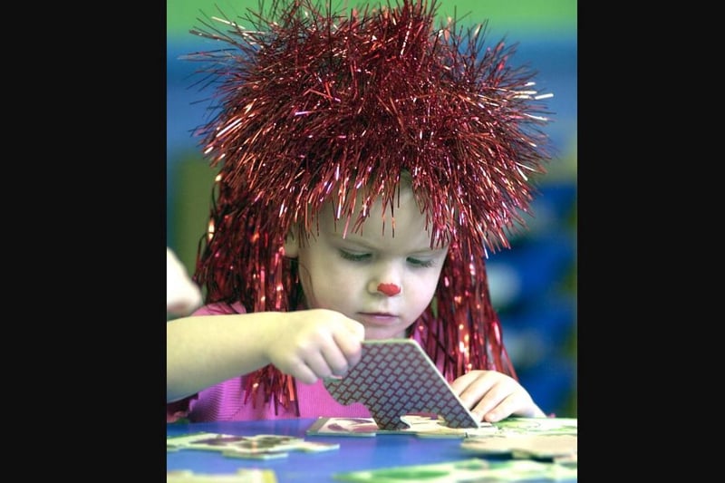 Big Hair day at Holy Trinity day nursery in aid of Comic Relief in 2005 with Ellie getting to grips with a jigsaw.