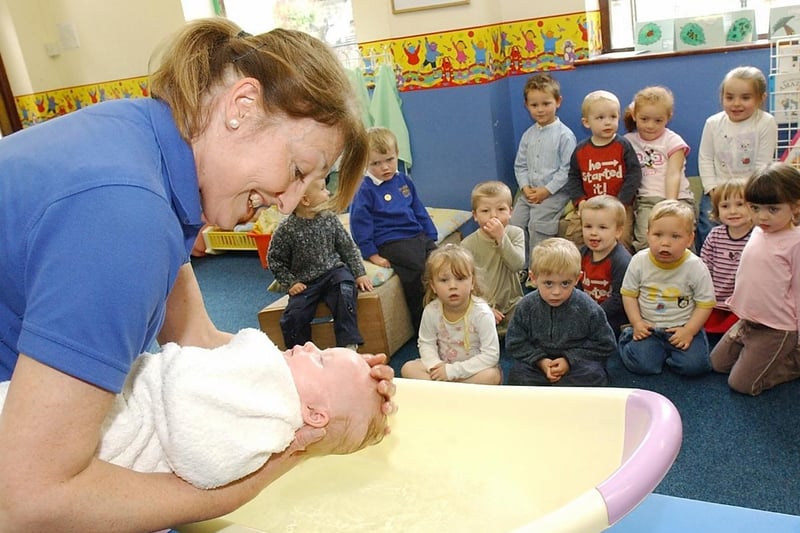 Baby bathing as part of growing project in 2005 - Trinity Nursery, Ossett. Val Ford (nursery manager) bathes baby Molly Quirke.