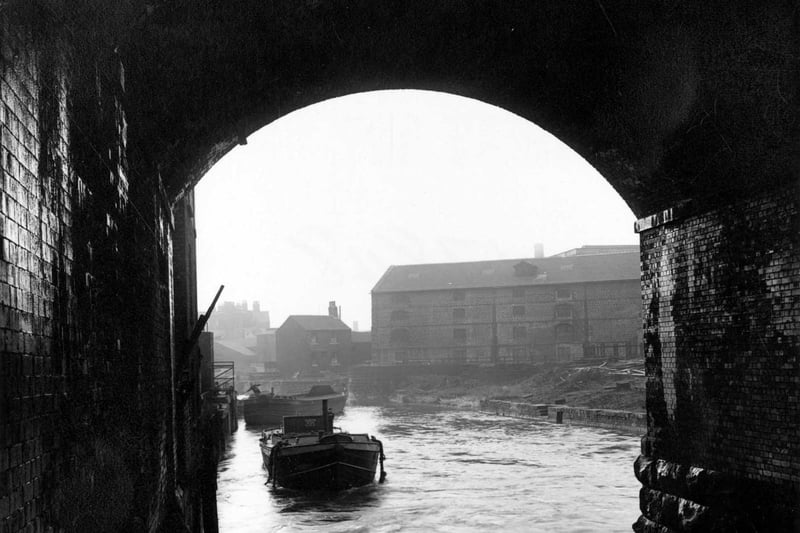 River Aire from inside of the Dark Arches, looking south towards old warehouses in January 1951.