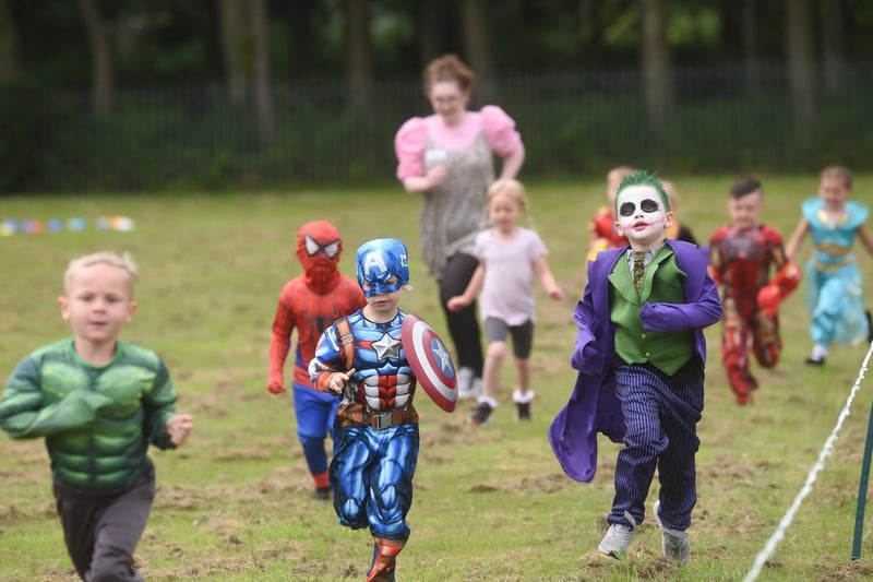 Heroes and villains ran together to raise money for a memorial garden in tribute to teaching assistant Cath Strangwood.