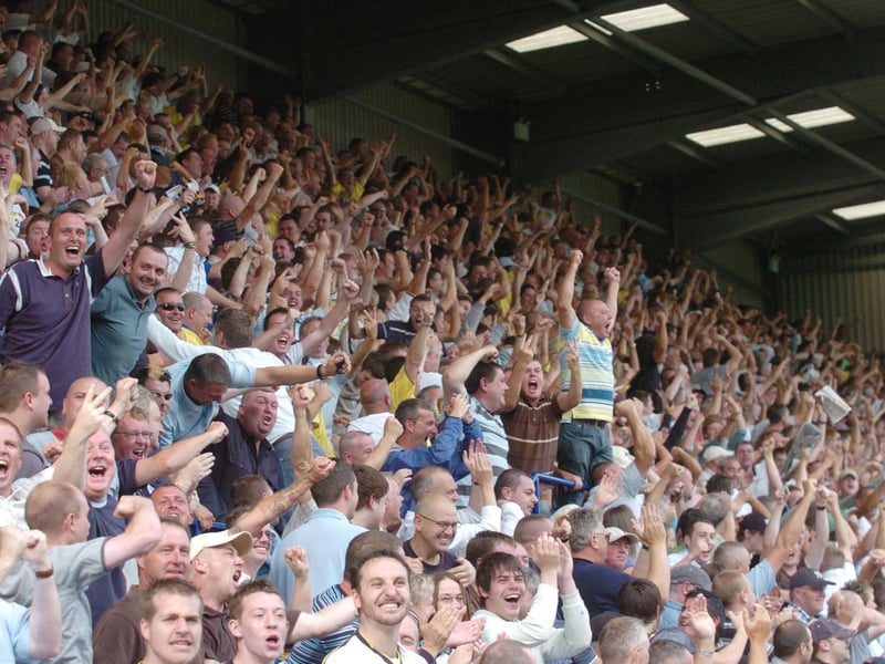 The travelling support celebrate at full-time.