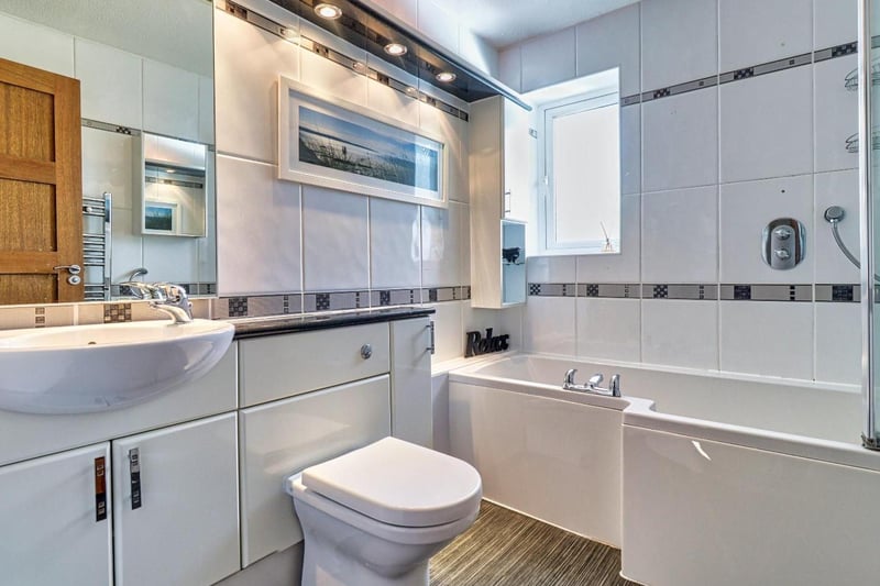 The family bathroom is a modern suite with a shower over the bath, toilet and pedestal wash hand basin. It also benefits from a chrome heated towel rail.