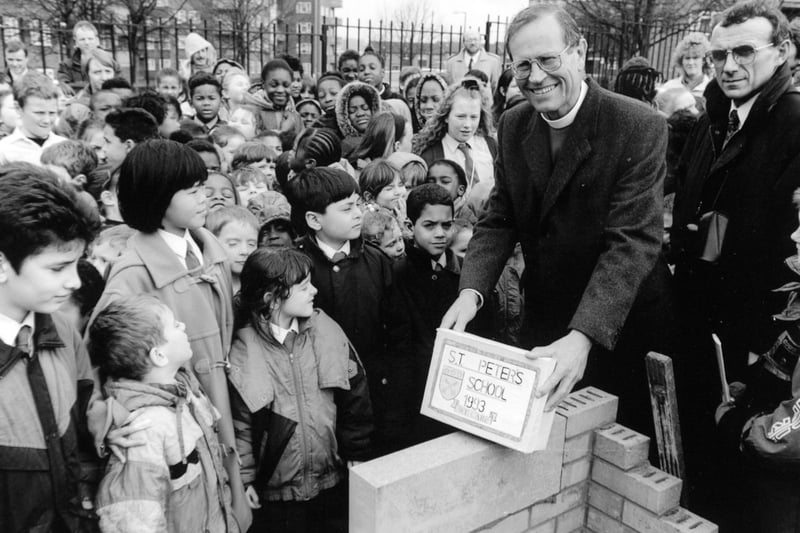 The Bishop of Ripon, the Right Reverend David Young is surrounded by children as he lays a foundation stone at the new St. Peter's C of E School in Burmantofts in January 1993.