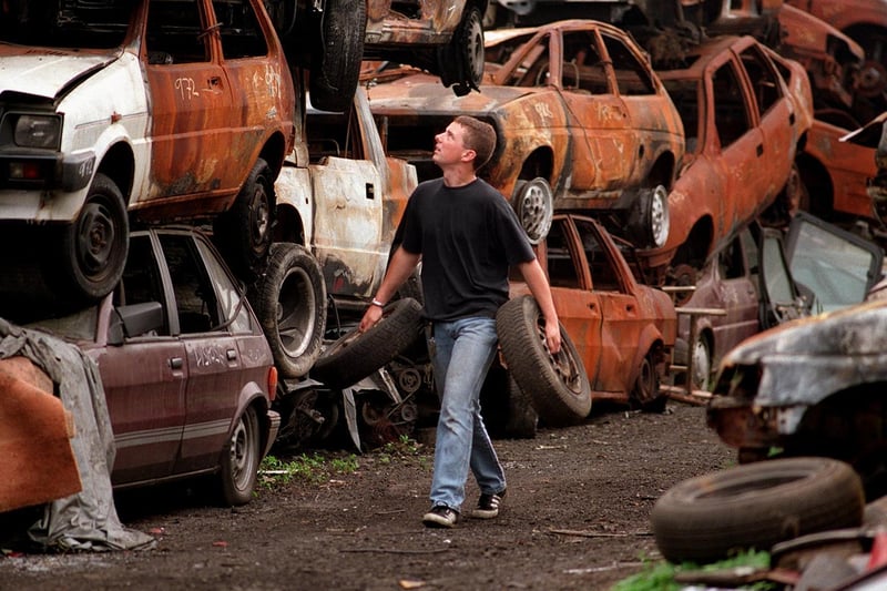 Recovery driver Mark Crisp, is surrounded by the remains of stolen cars in the storage yard at Dragon Bridge Auto in August 1997.